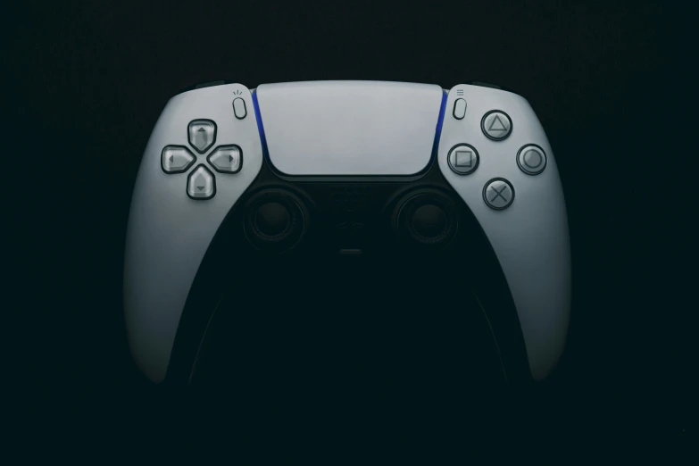 the white wii controller stands in the dark