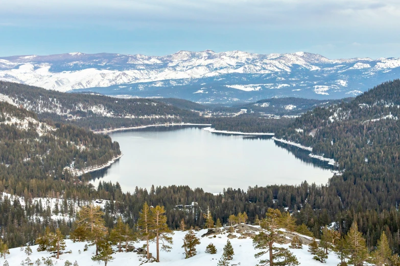 a snow covered mountain is seen from the top of a hill