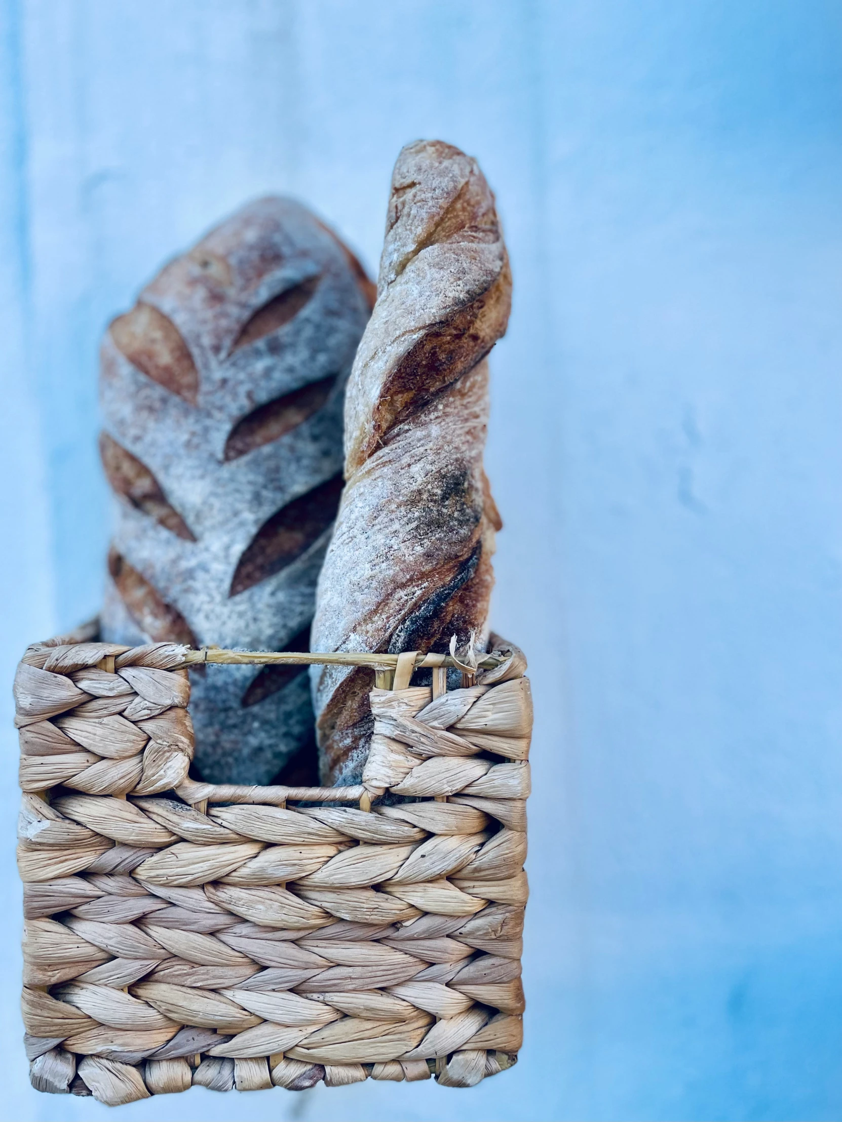 a close up of a basket that has many different bread items in it