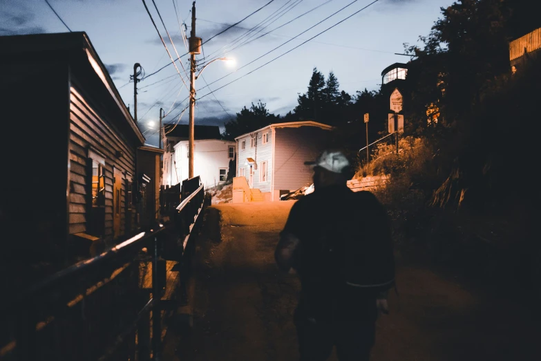 a man is walking down the narrow path at night