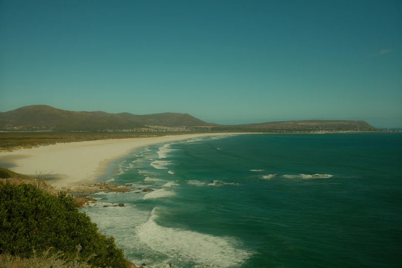 an empty sandy beach near the ocean