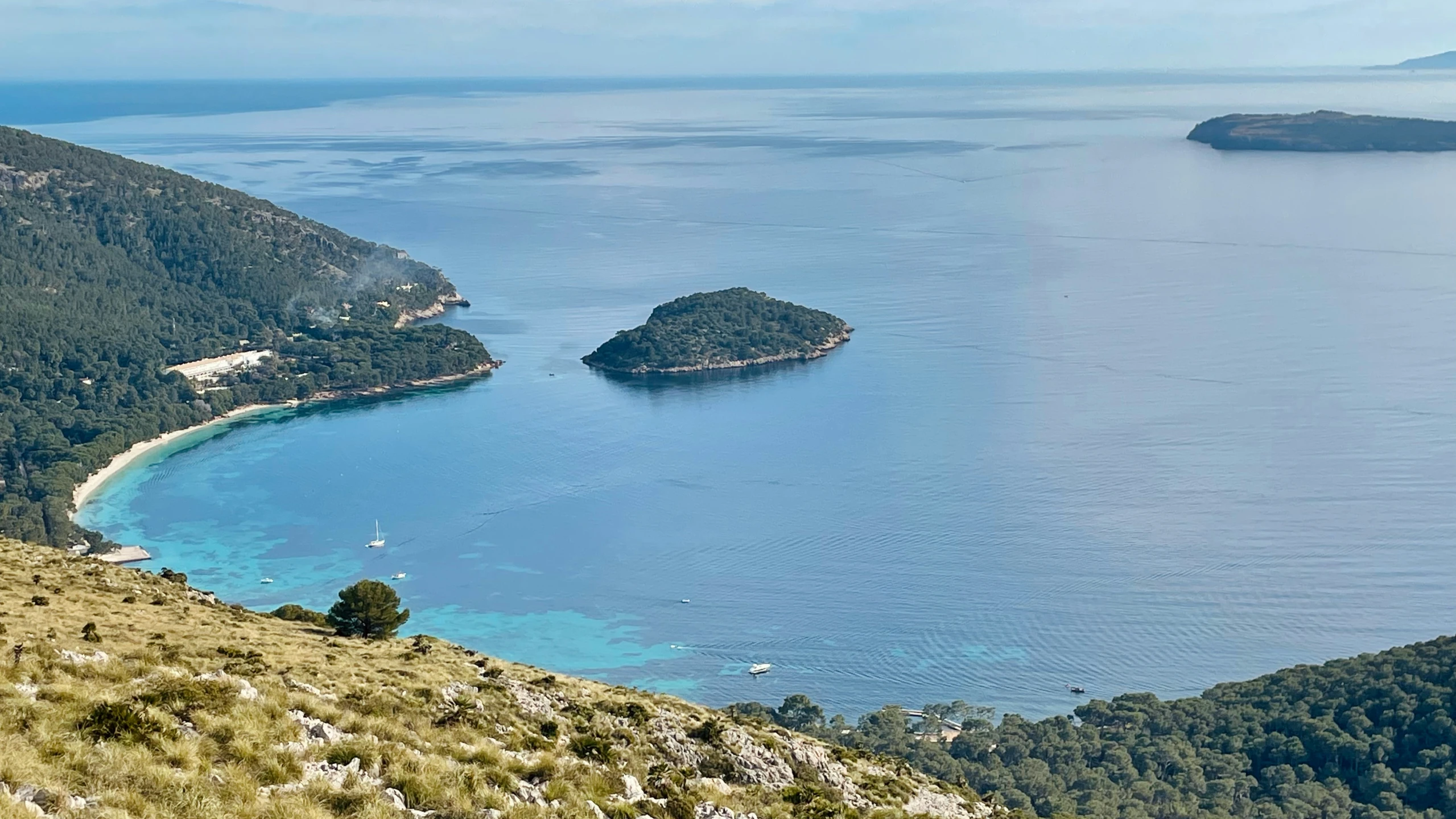 the view of some pretty blue water surrounded by mountains