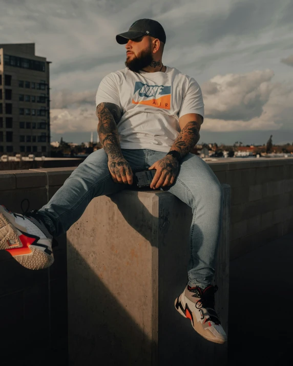 man in hat sitting on ledge of city