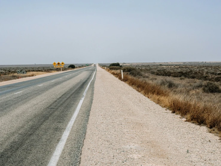 a two lane highway with a small yellow sign