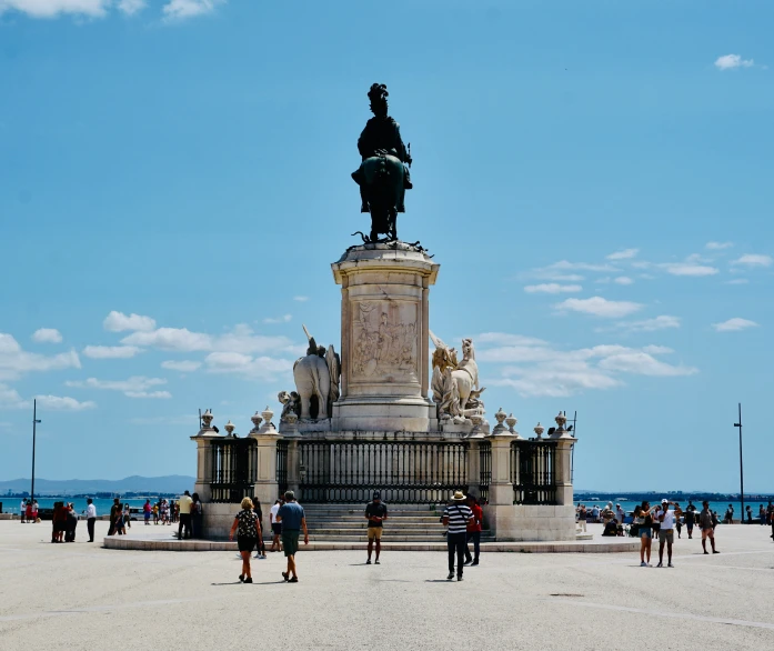 a group of people walking around a statue