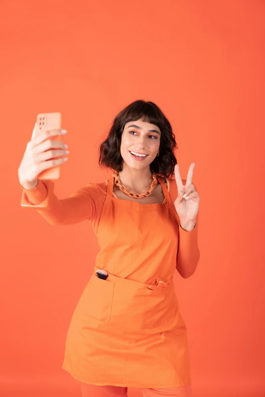 a woman in an orange dress and a cell phone