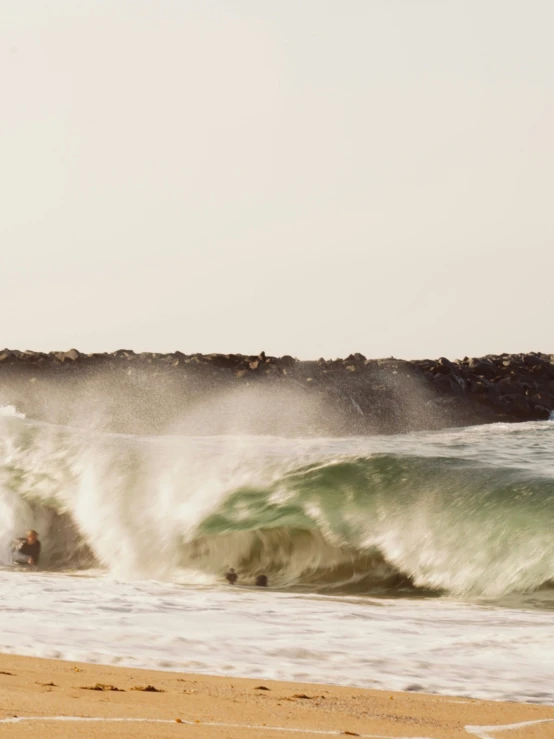 a couple of people ride surfboards down a large wave