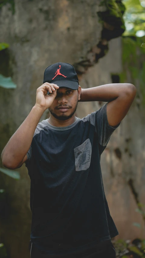 man wearing jordan cap standing near tree in park