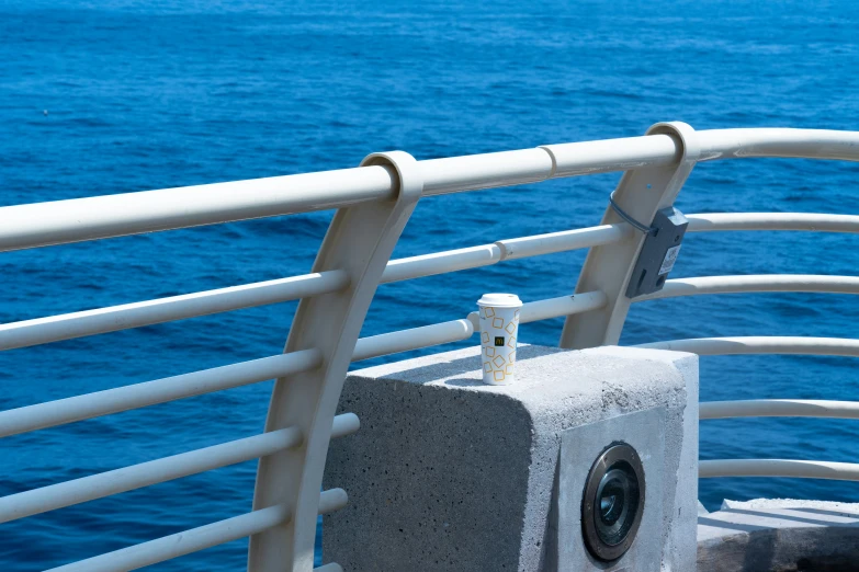 the camera on the left side of the seat is attached to the railing above the water