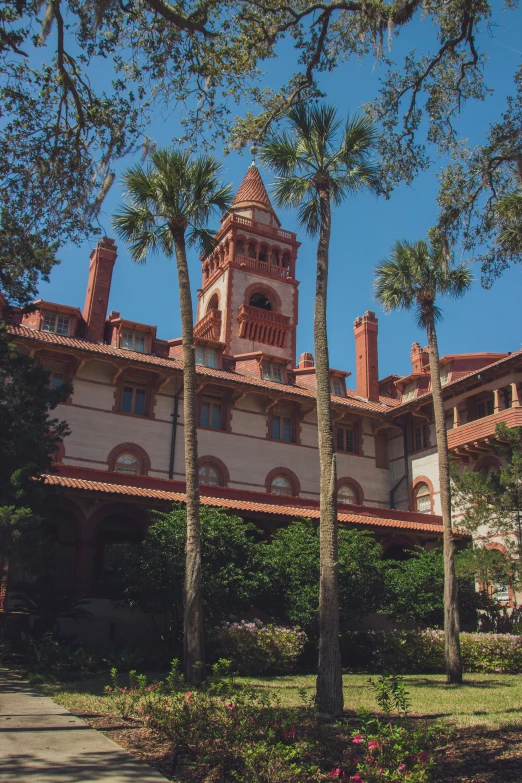 the outside of a large white building with tall trees