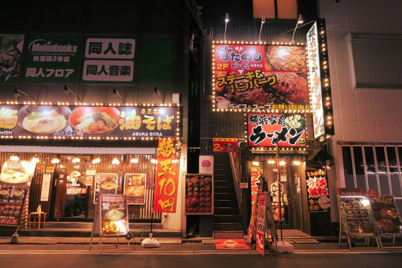 storefronts and lights on a city street at night