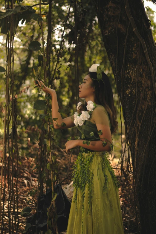 a woman standing in a forest holding a white flower