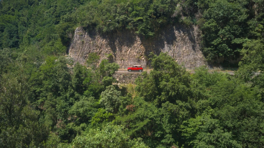 a red truck is near some big rocks