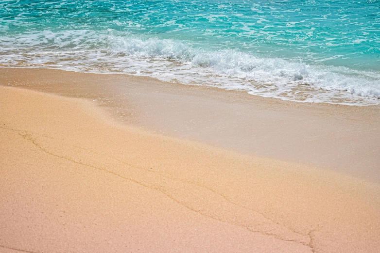 waves are on the beach and one wave is turning to the water