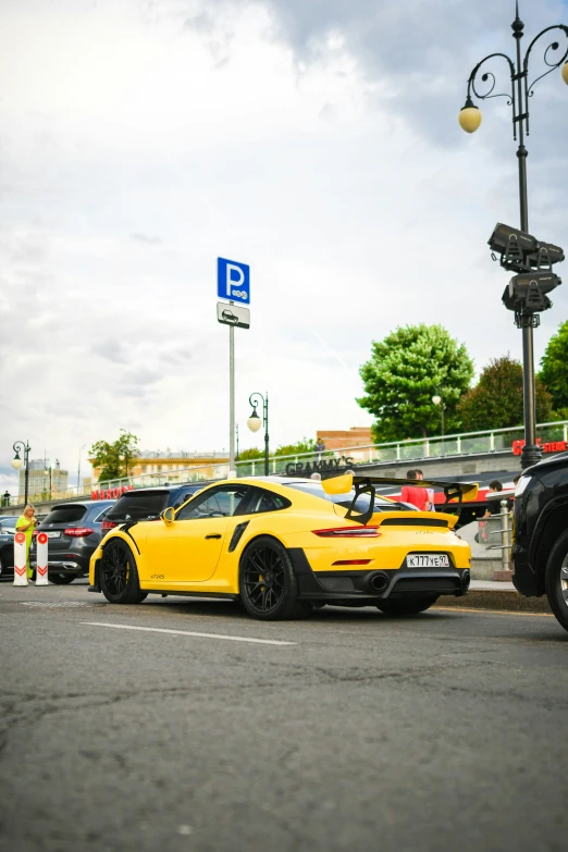 a yellow sports car is parked on the side of the road