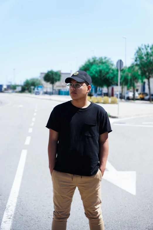 a man standing in a parking lot next to the street