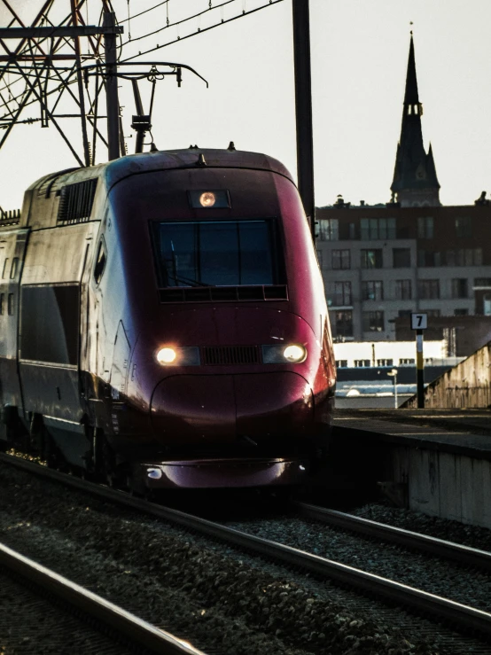 a train on a track with buildings in the background