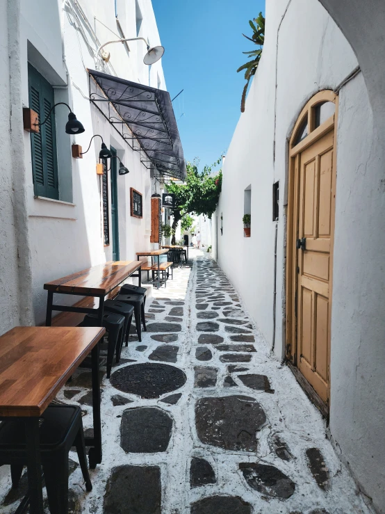 an outdoor table and benches sit on the street