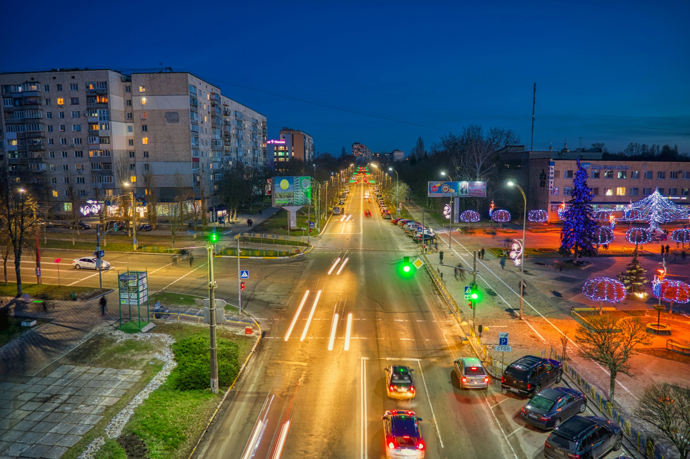 a city street with cars moving along it's intersection at night