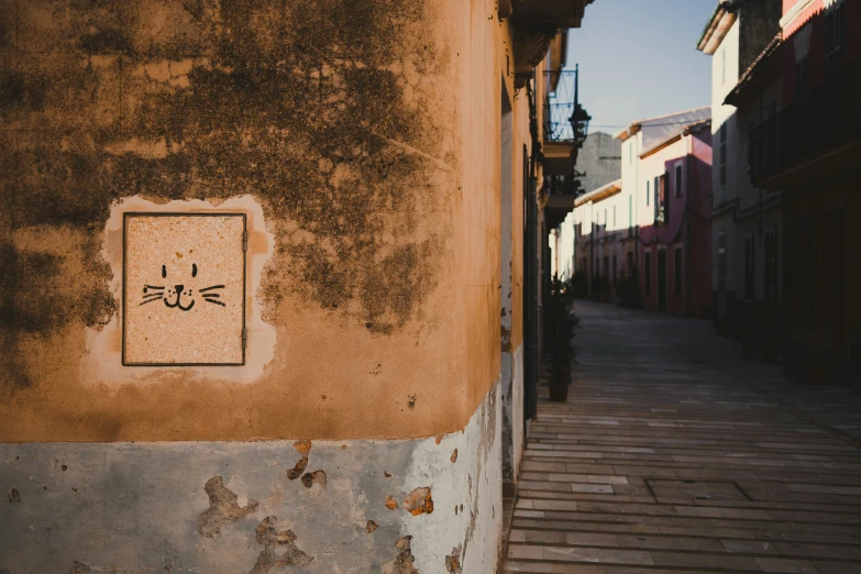 a building in an alley way with a square sign on it