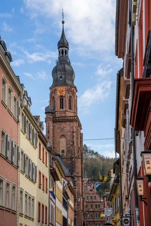 a tall church tower towering over a city next to tall buildings