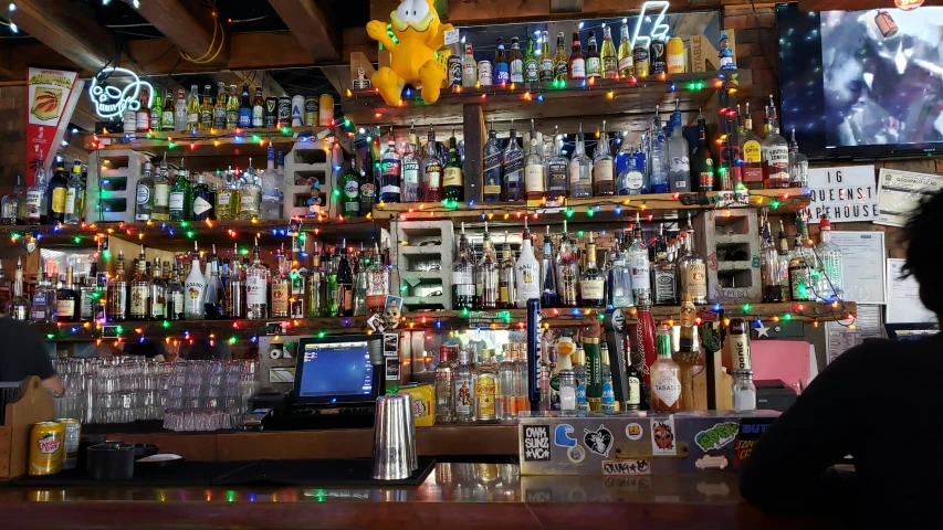 a bar with many bottles and a television in the corner