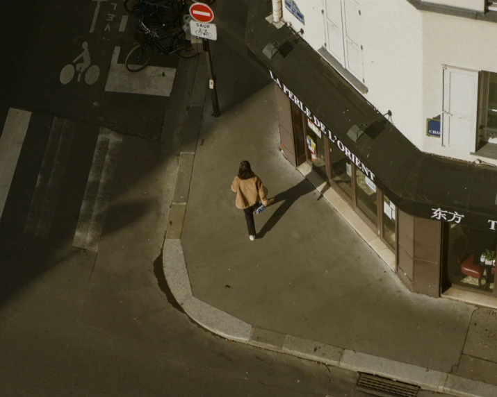 a man walking down the side walk of a street next to a building