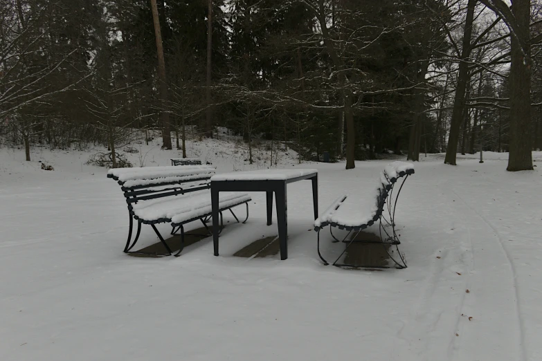 an image of a bench and table in the snow