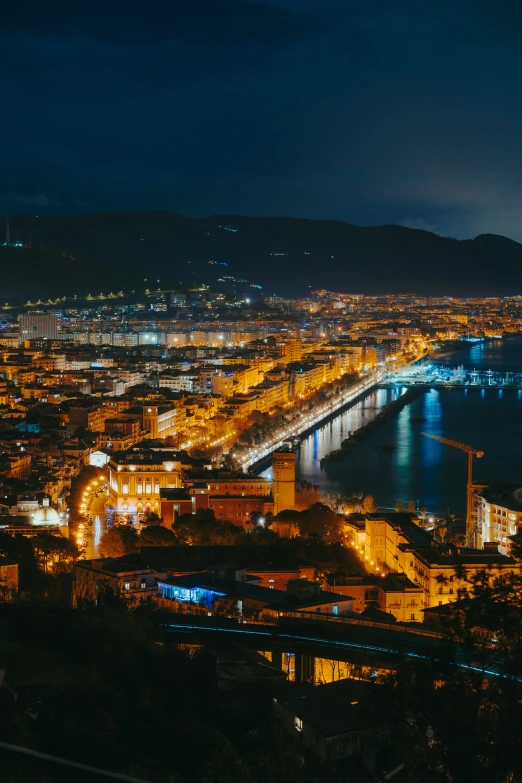 a night view of a large bridge going into a city