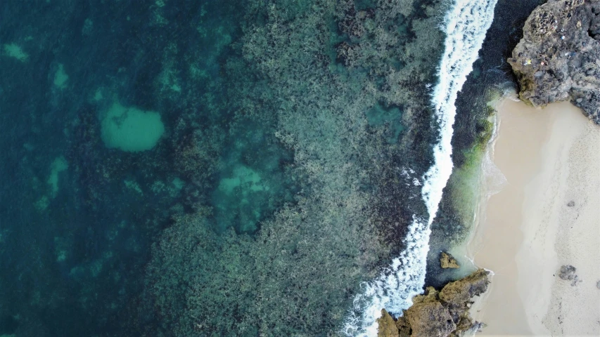 an aerial view of a body of water near the beach