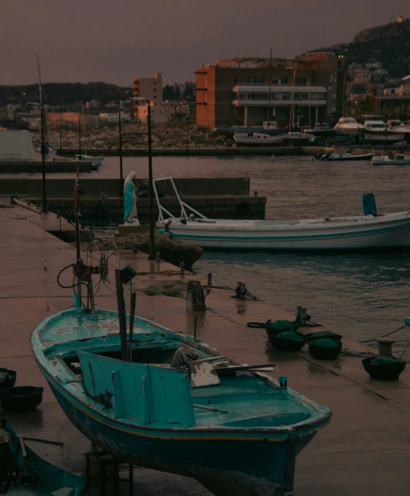 the boats are parked in the harbor on a rainy day