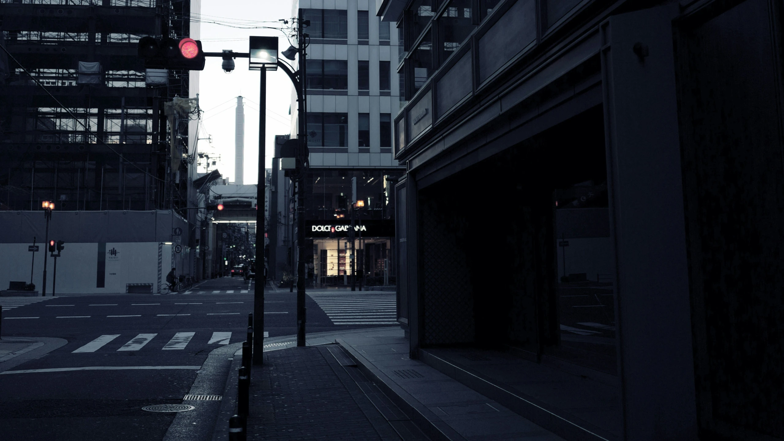 an urban street is lit with traffic signals at dusk