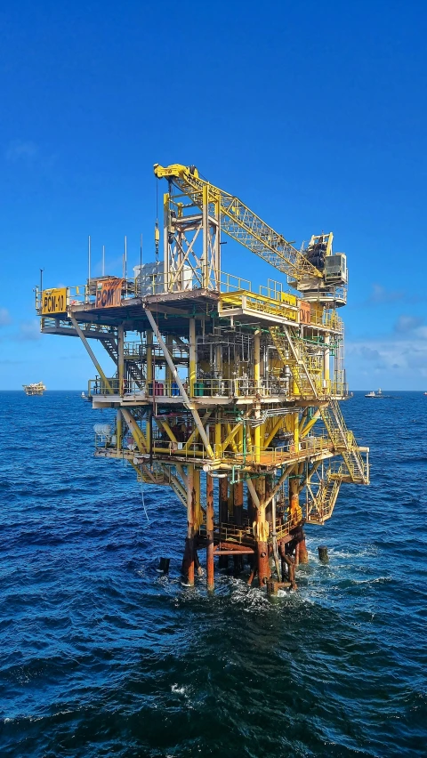 a yellow and black drilling rig sitting on top of the ocean