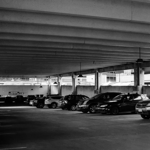 a parking lot filled with lots of cars under a bridge