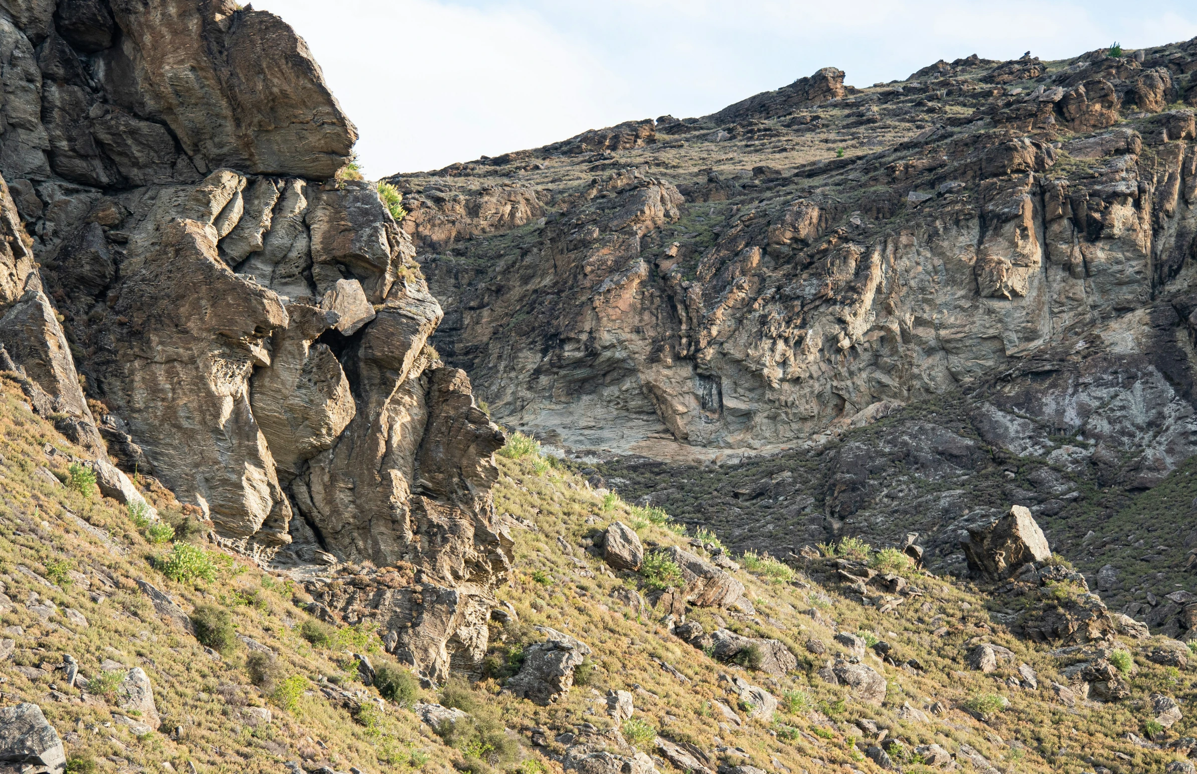 a steep, rocky mountain has a bunch of rocks on it