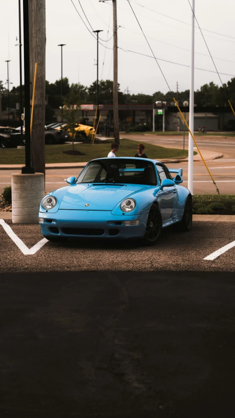 two people sitting on the hood of a sports car