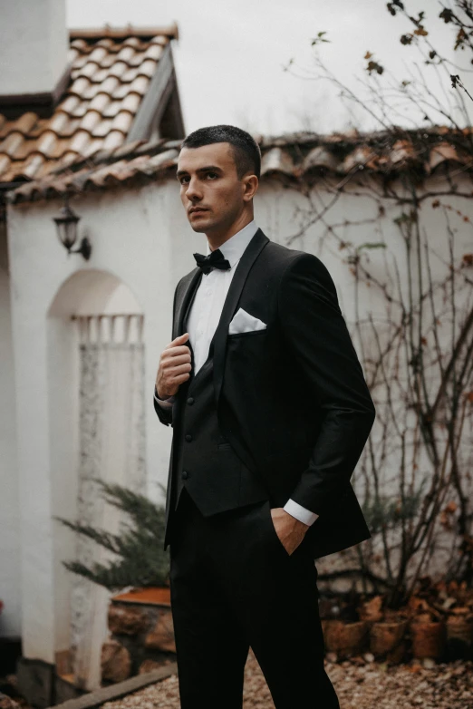 a man is dressed in a black tuxedo