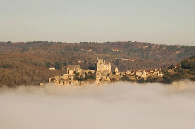 a castle perched on a hilltop above the clouds
