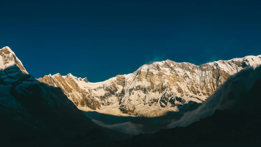 the mountains have a white surface against a dark sky