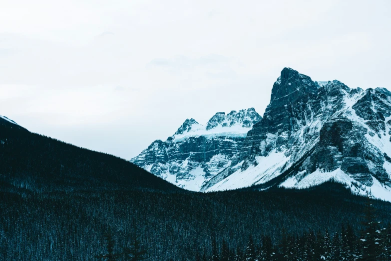 the snow - covered mountains are rising up to the sky