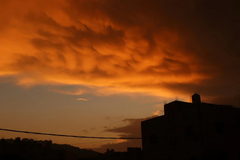 the sky is orange with a red cloud in the middle