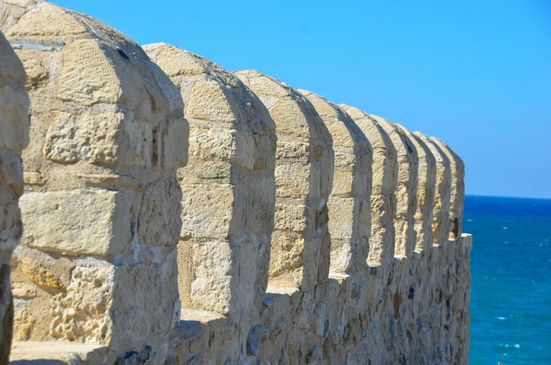a stone wall sitting along the edge of a beach