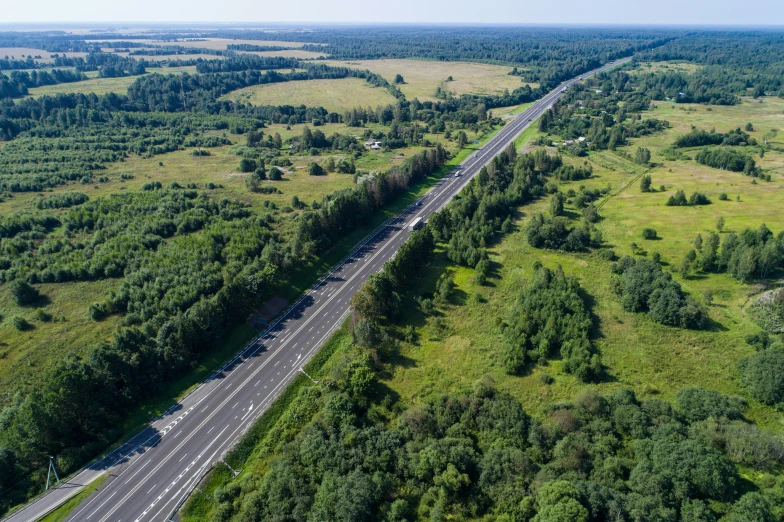 an overhead s shows a road through the woods