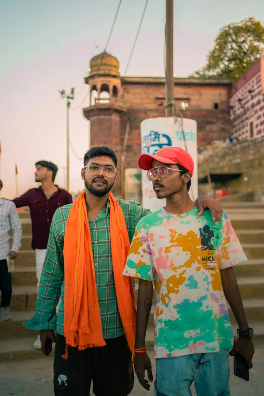 two men stand beside each other at sunset