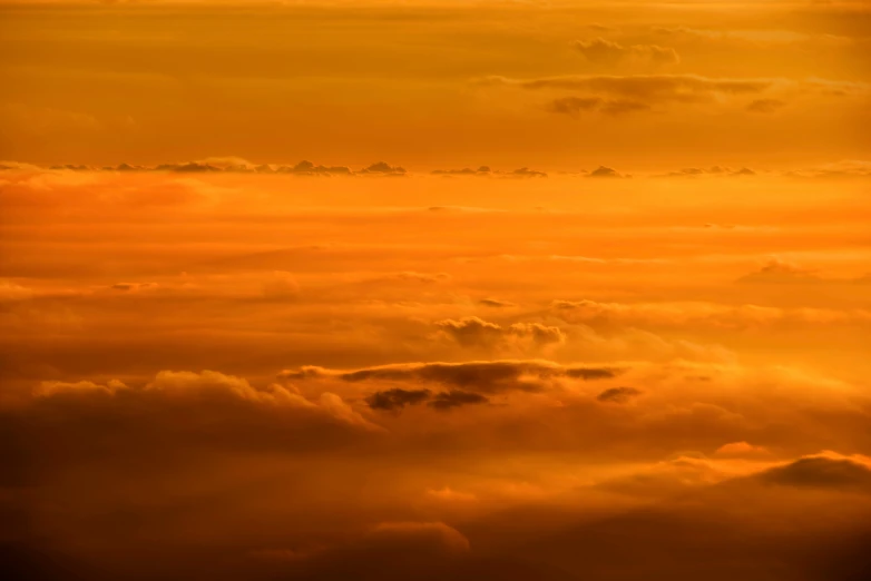 an airplane flying in the sky at sunset