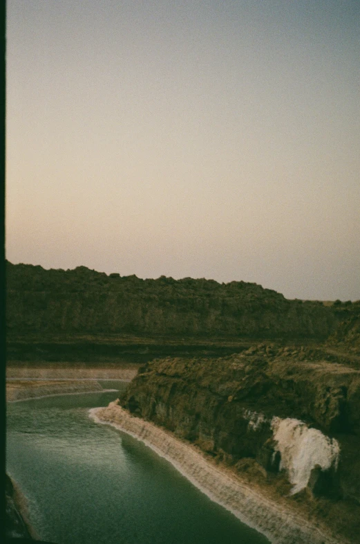 a large body of water near a hilly area