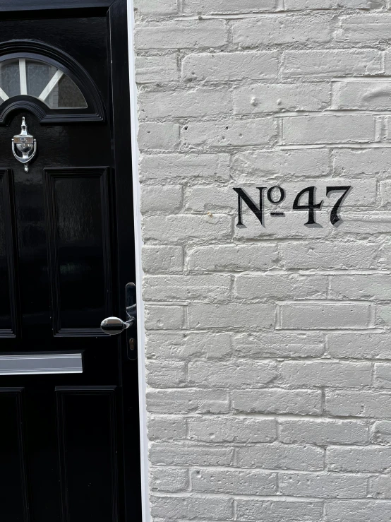 black door with graffiti writing on brick wall