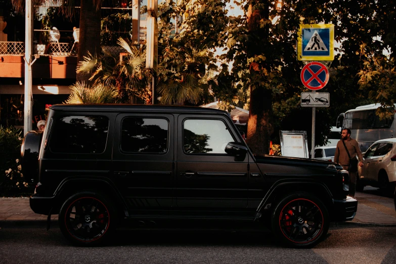 a black mercedes parked next to a building in front of traffic