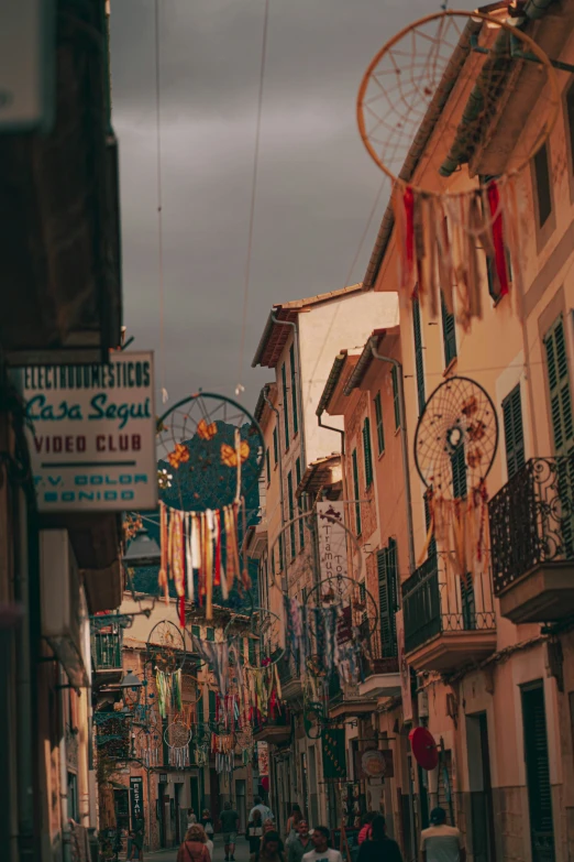 people walk down an alley with many different stores on the sides