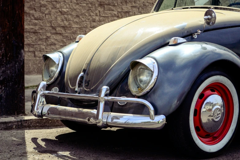 an old car sits parked near a brick wall